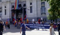 Imagen de algunos manifestantes junto la pancarta con el lema: "Orgullosos de nuestra historia". Al fondo, colgada en el Ayuntamiento, la bandera del arcoiris gay.