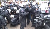 Policías alemanes tratan de detener una pelea masiva entre migrantes. (Imagen tomada de un vídeo de SAT1).